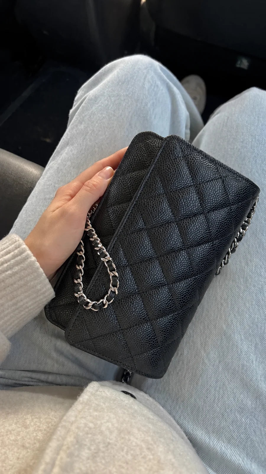A black quilted chain bag styled with washed denim